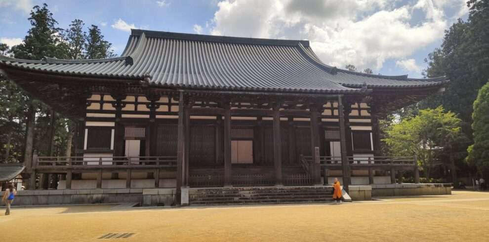 Buddhist shrine located in the famous Mount Koya and a buddhist monk walking in front of the shrine