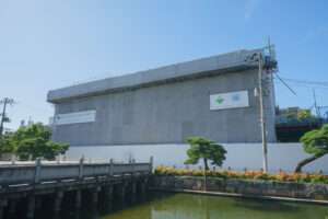 Building in renovation covered by a grey cover and with logo from the reconstruction company