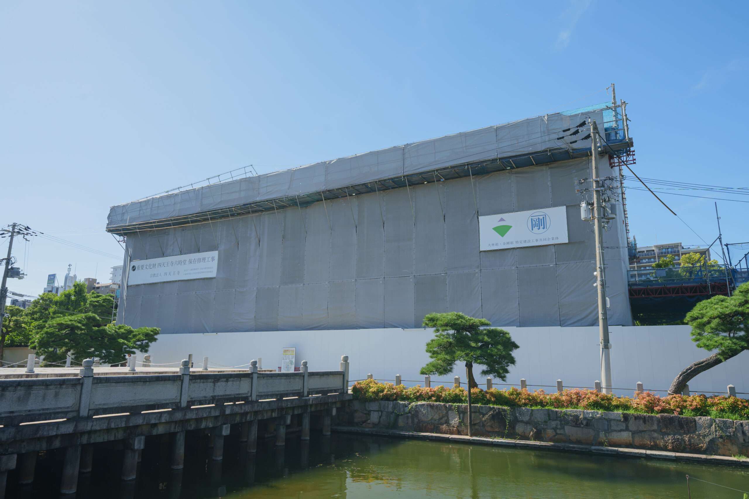 Building in renovation covered by a grey cover and with logo from the reconstruction company