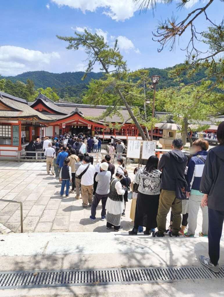 queue leading up to the entrance to Itsukushima Shrine in Miyajima, Hiroshima, Japan